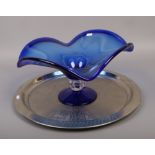 A large blue Murano glass pedestal bowl on white metal tray.