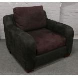 A modern suede upholstered arm chair raised on block feet.