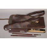 A leather gun slip, along with a boxed gun cleaning kit and a gun cleaning rod.