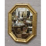 An octagonal gilded wall mirror.