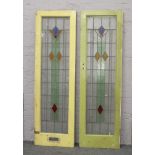 A pair of yellow painted lead glazed coloured glass doors.