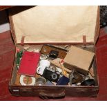 A suitcase of miscellaneous to include Metamec clock, gas mask, Smeha camera etc.