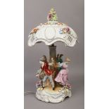 An ornate Capodimonte style table lamp with porcelain shade raised over figural base.Condition