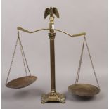 A set of brass scales with eagle finial and raised on a Corinthian column.