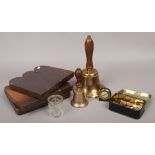 Two brass hand bells, tin of foreign coins, Smith Empire travel clock and three stoneware garden