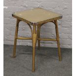 A glass top gold basketware and bamboo occasional table.