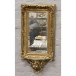 A gilded pier mirror with under tier on putti corbel having bevelled glass.