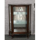 A mahogany single door china cabinet raised on squat cabriole legs.