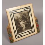 An Art Deco easel photograph frame with barbola decoration to the side supports, 30cm high.Condition