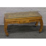 A carved hardwood Chinese style coffee table with glass top.