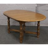 An Ercol Golden Dawn oval extending dining table with inbuilt leaf raised on turned square legs,