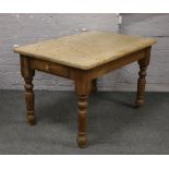 A pine farmhouse style kitchen table raised over turned legs with drawer to one end, 122cm x 84cm