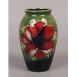 A Moorcroft tube lined vase decorated with anemone flowers, 11cm tall.