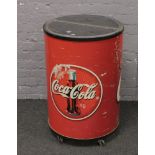 An advertising Coca Cola drinks chiller of cylindrical form.