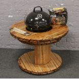 A cable drum style table incorporating a kettle barbecue.