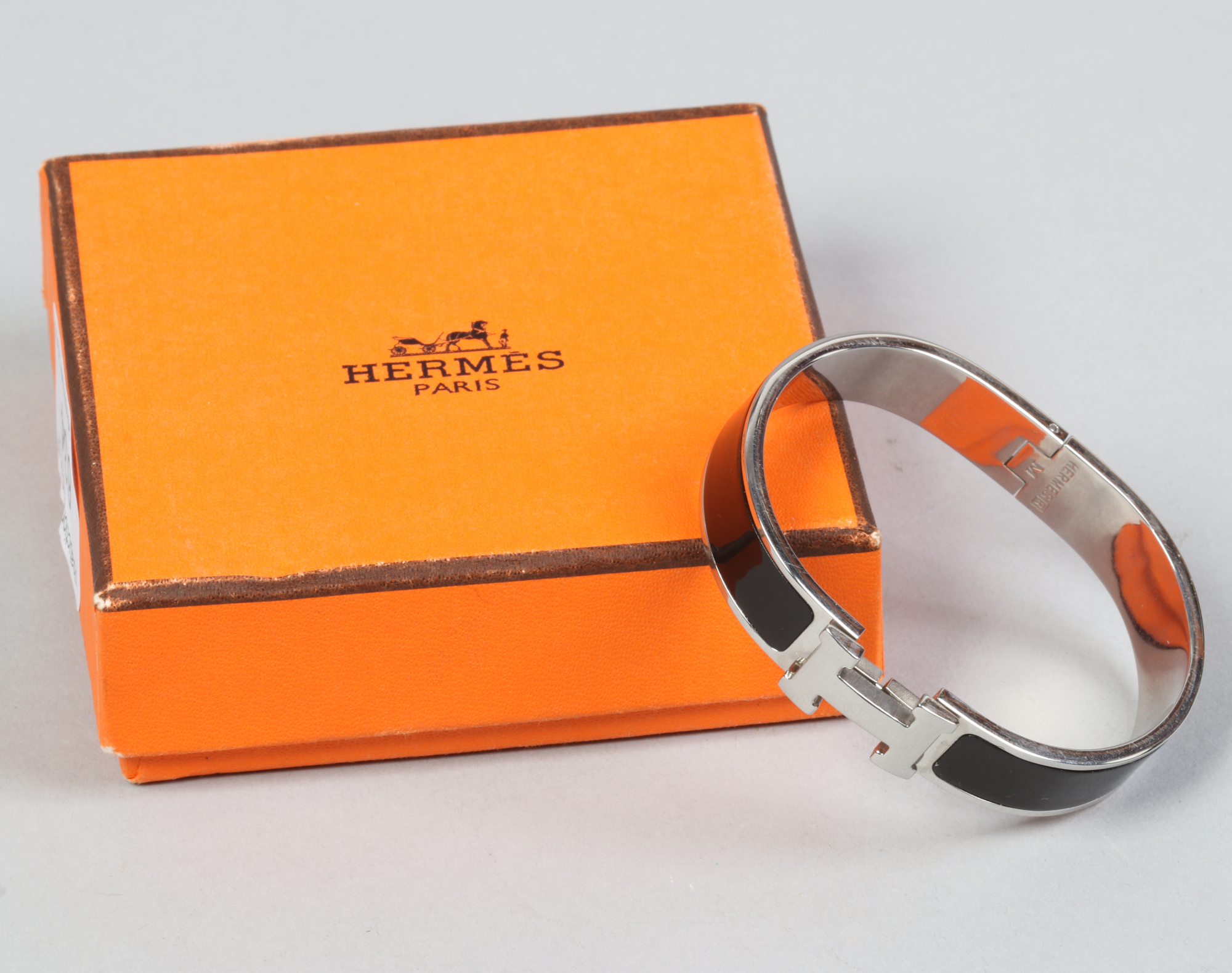 A boxed Hermes Paris Clic H bracelet with black enamel decoration.