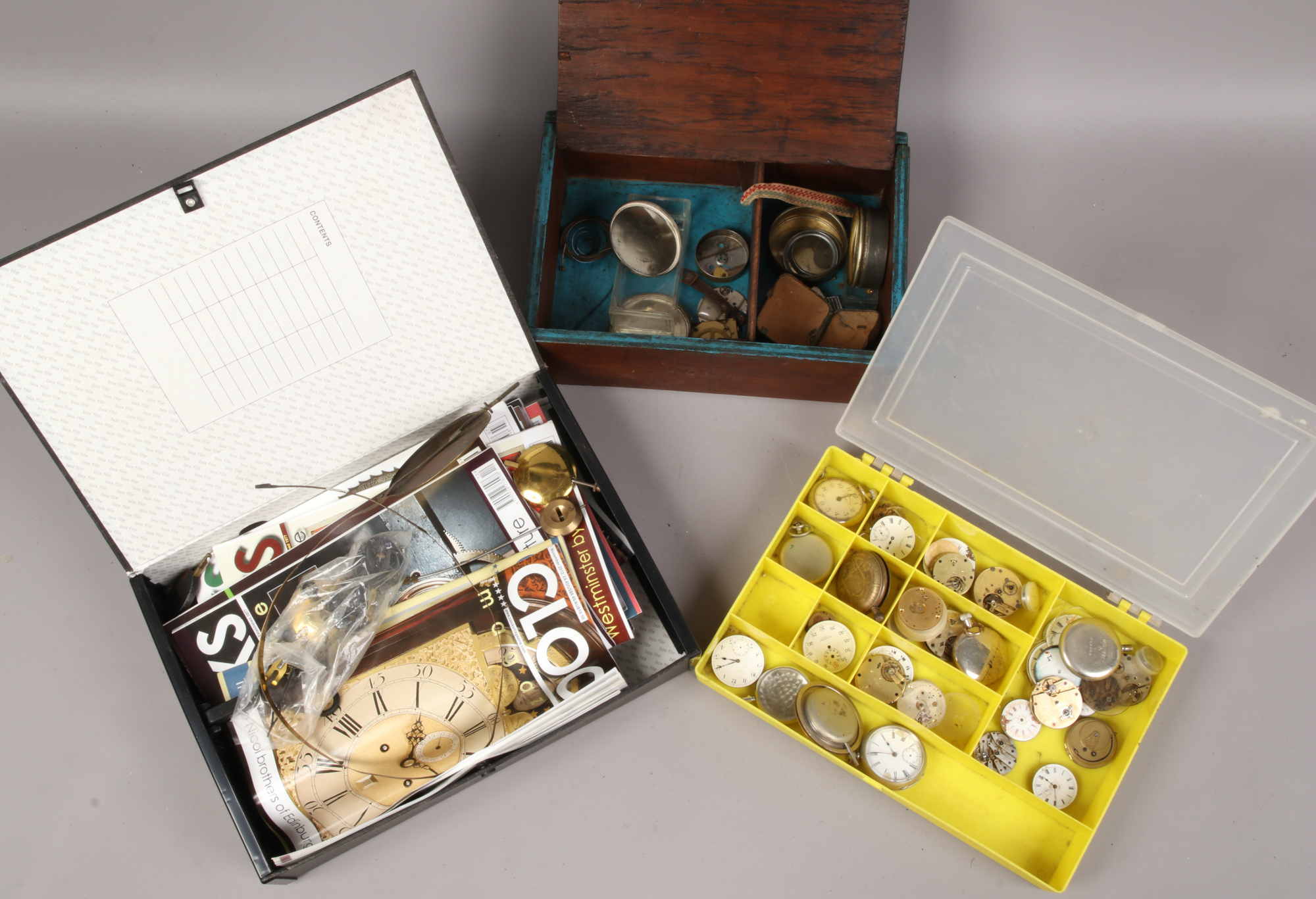 Two boxes of watch repairers spare parts including pocket watch movements etc.