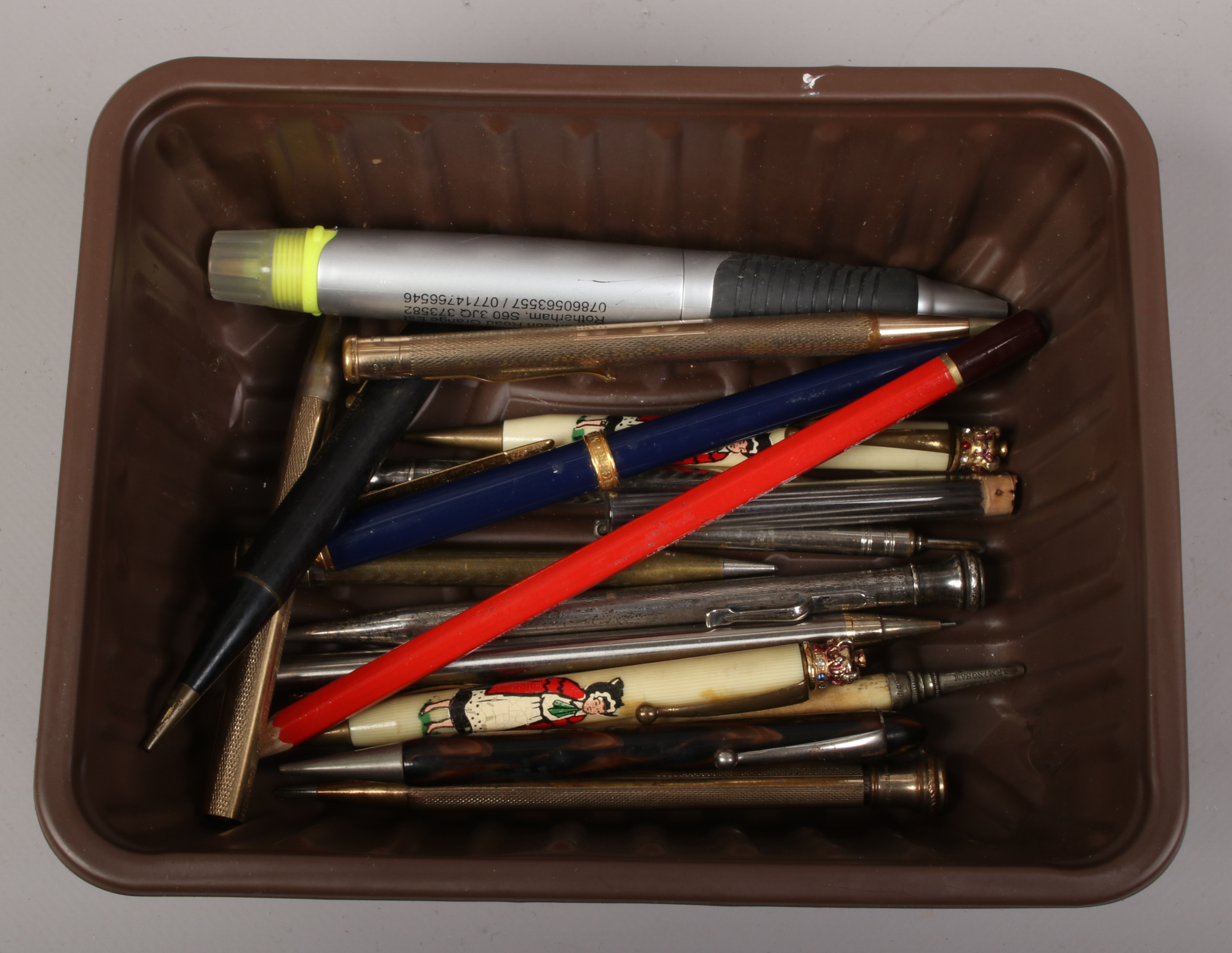 A box of pens and pencils to include Walpamor propelling pencil, Messenger ballpoint pen, rolled