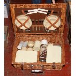 A wicker picnic hamper with contents of stainless steel cutlery and food storage containers.