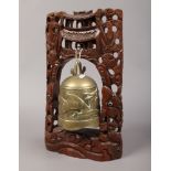 A Chinese bronze prayer bell on carved hardwood stand.