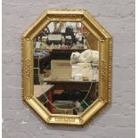 An octagonal gilded wall mirror.