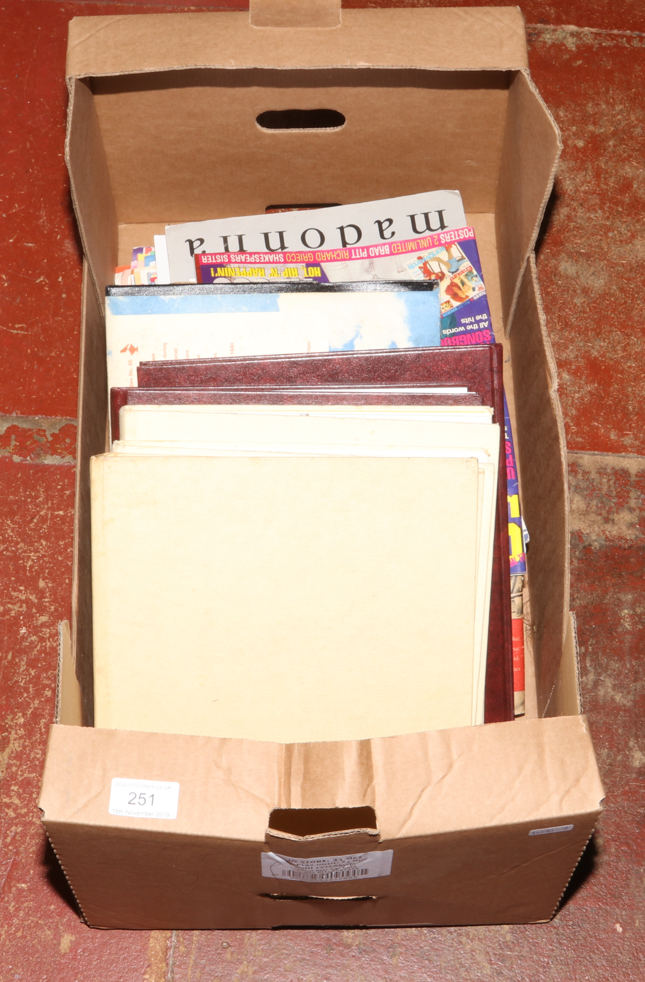 A box of mostly memorabilia to include Beatles, Madonna sheet music, Lladro collectors catalogue