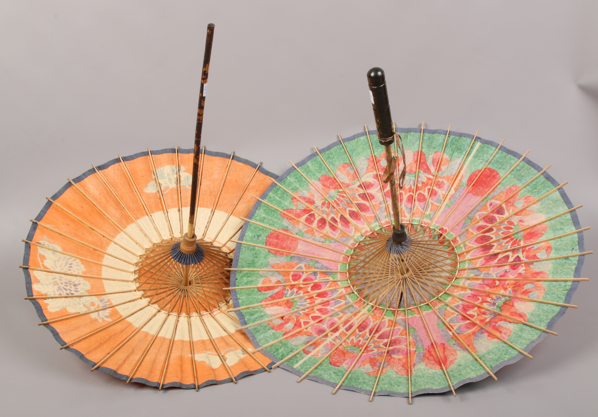 Two Chinese parasols decorated with colourful flowers and butterflies.