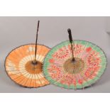 Two Chinese parasols decorated with colourful flowers and butterflies.