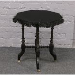 A Victorian ebonised gypsy table raised over turned and castered base.