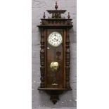 A mahogany cased Vienna Springer wall clock with white enamel dial chiming on a coiled gong.