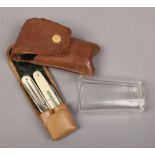 A vintage leather cased campaign folding cutlery set along with glass beaker.Condition report