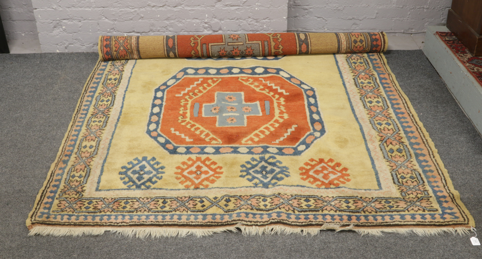 A yellow ground wool rug with geometric design and central medallion.