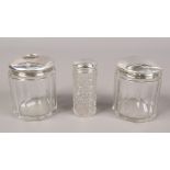 Three silver top glass jars, two largest jars assayed Birmingham 1946.