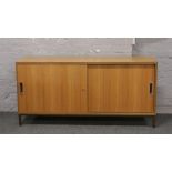 A retro teak effect sideboard with sliding doors.