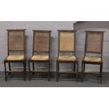 A set of four rush seat bergere back dining chairs raised on barleytwist supports.