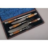 A cased five piece superior cutlery horn and white metal handled carving set.