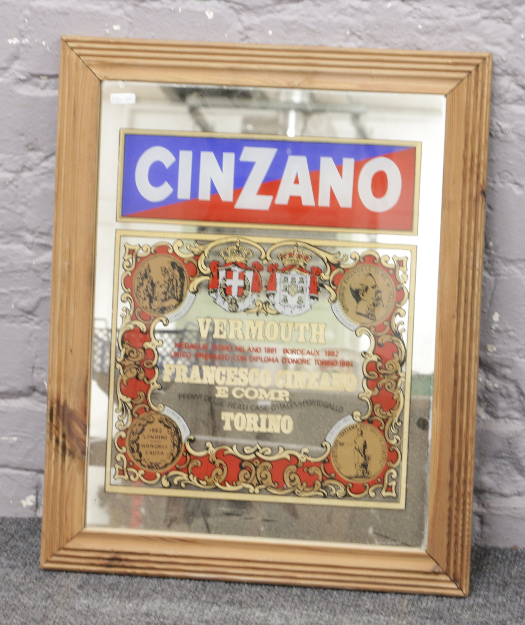 A framed Cinzano Vermouth advertising mirror.