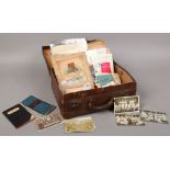 A vintage suitcase and contents of ephemera including monochrome postcards - football and cricket,