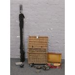 A wicker fishing basket and contents of fishing reels etc, along with a fishing rod.