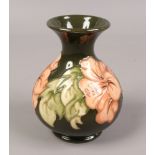 A Moorcroft green ground baluster vase in the hibiscus design, 13cm tall.