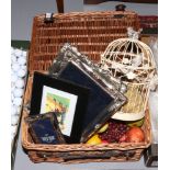 A basket of dried fruit decorative bird cage and silver plated picture frames.