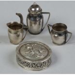 A continental silver dolls three part teaset and a pill box decorated with a putti, both marked.
