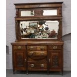 A carved bow front mirror back sideboard with reeded column supports.