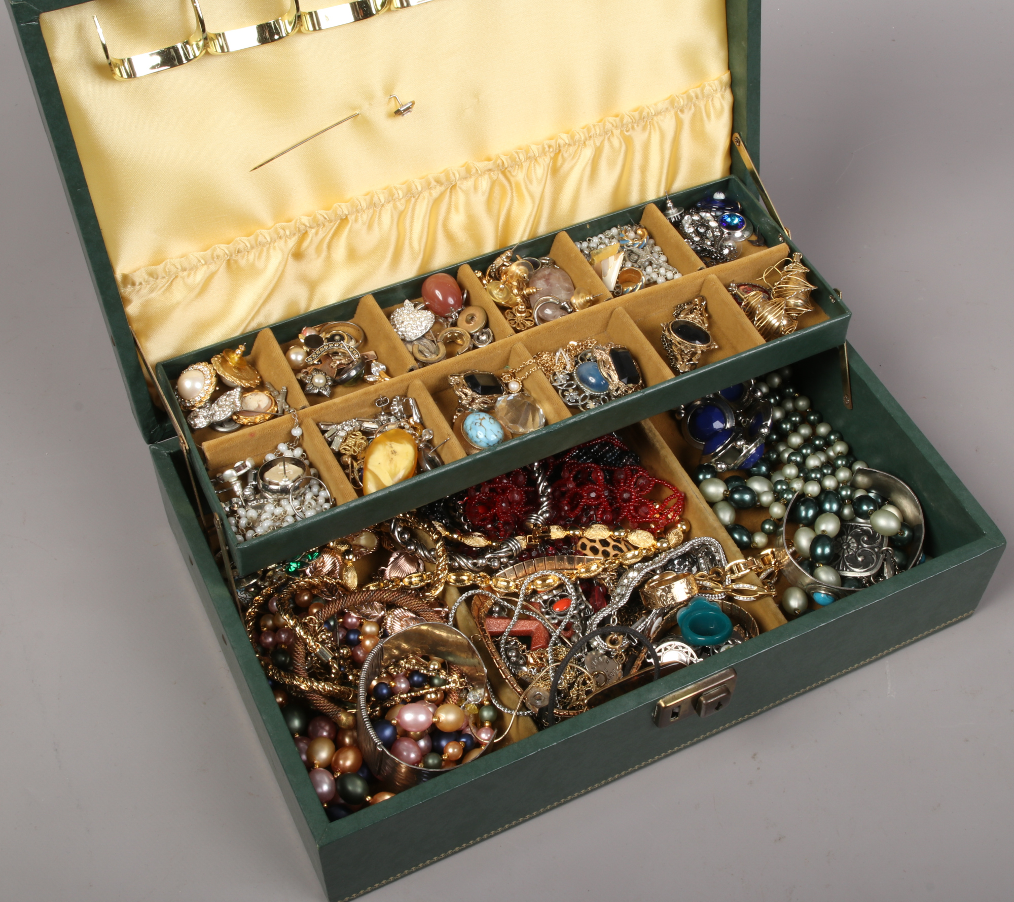 A jewellery box of costume jewellery to include beads, bangles, earrings, brooches etc.