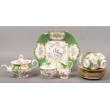 A collection of Minton teawares decorated with colourful flowers and birds.