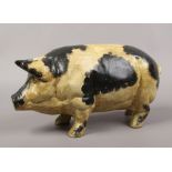A painted cast iron model of a black and white pig.