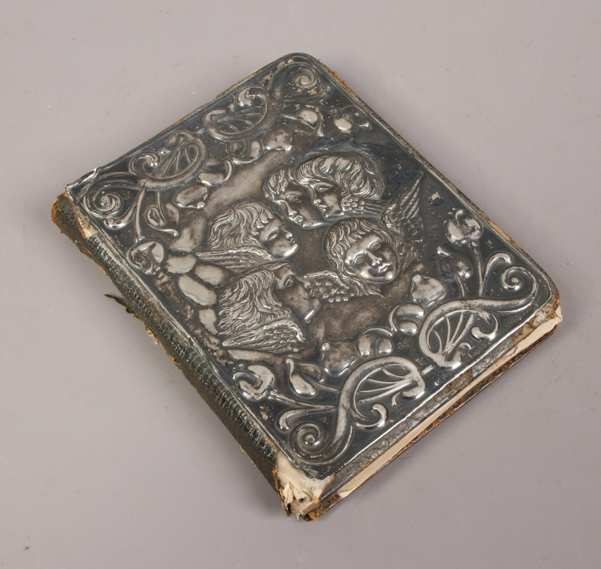 An Edwardian silver mounted motor trip notebook, the front with repousse decoration depicting