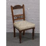 A Victorian mahogany carved back chair raised on turned supports.