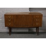 A mahogany sideboard with drop down centre raised on tapering supports.