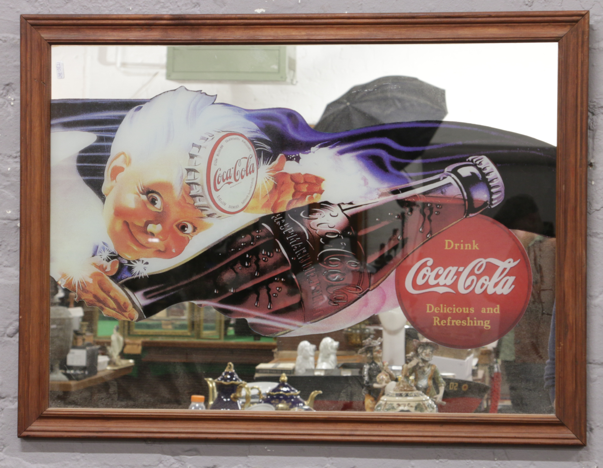 A framed Coca Cola advertising wall mirror.